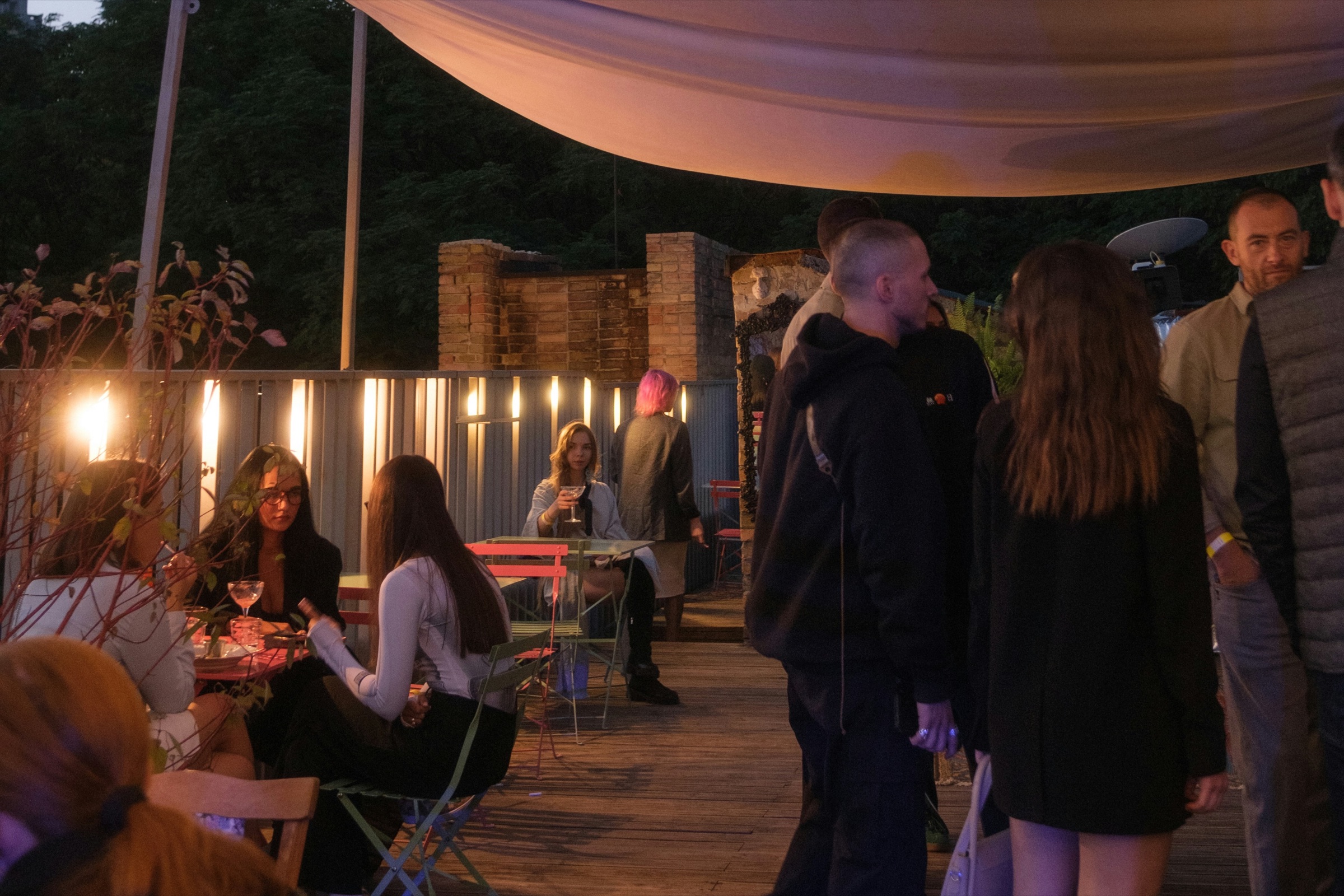 Guests talking around rooftop tables under warm lights at a Just Singles Dubai evening