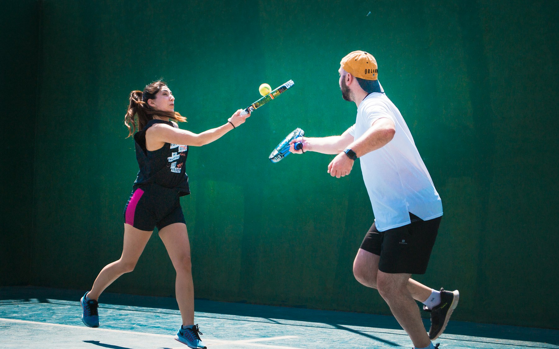 Two members mid-rally on a padel court